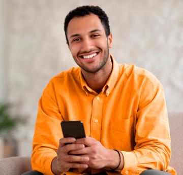 Pessoa com celular na mão sorrindo